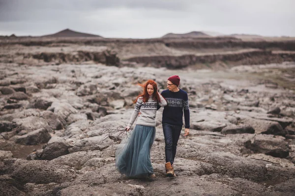 Влюбленная пара, гуляющая по Исландии. Каменная вулканическая пустыня вокруг — стоковое фото