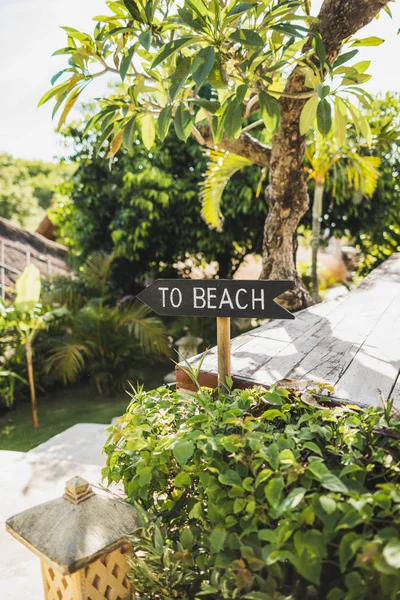 Drewniany wskaźnik ze znakiem To Beach w tropikalnym ogrodzie — Zdjęcie stockowe