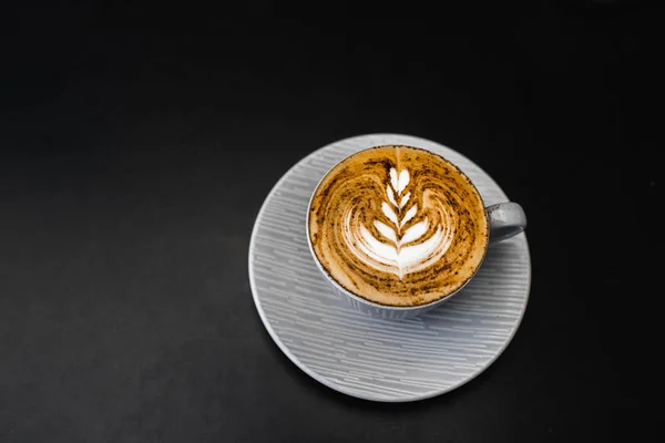 Xícara cinza de cappuccino fresco com chocolate em espuma em blac escuro — Fotografia de Stock