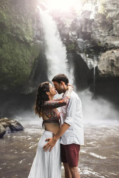 Young couple in love kissing with amazing view of  Tegenungan ca — Stock Photo, Image