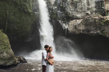 Genç ve hamile bir çift, Tegenungan C manzarasına bayılıyorlar.