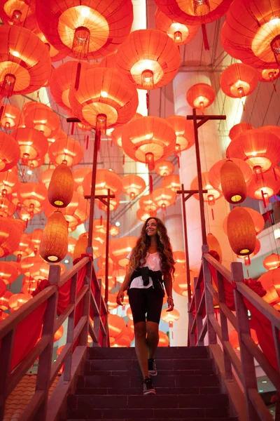 Happy admiring woman enjoying traditional red lanterns decorated — Stock Photo, Image