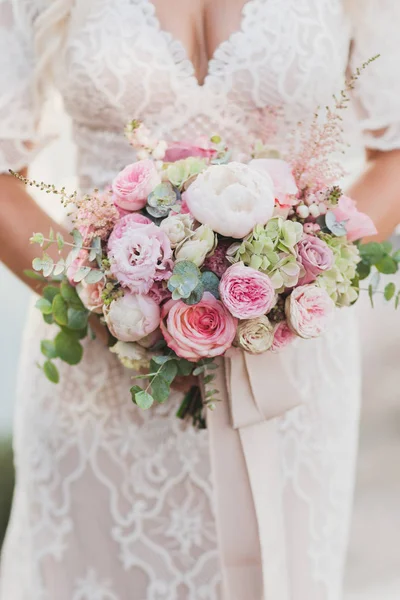 Bride holding in hands small wedding bouquet in pastel colors. L — Stock Photo, Image