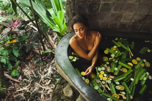 Piękna młoda kobieta korzystających w spa na świeżym powietrzu. Luksusowa kąpiel Kamienna — Zdjęcie stockowe
