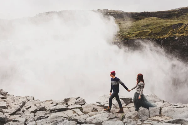 若いですスタイリッシュなカップルで愛一緒に有名なアイスランドの近くを歩く — ストック写真