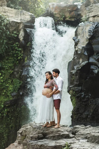 Giovane coppia incinta innamorata con splendida vista di Tegenungan c — Foto Stock