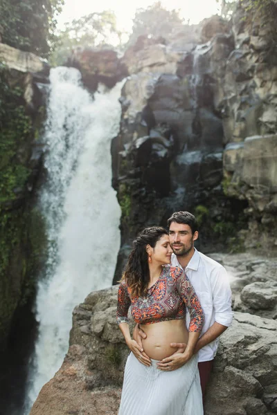 Genç ve hamile bir çift, Tegenungan C manzarasına bayılıyorlar.