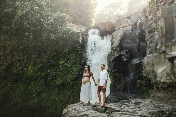 Giovane coppia incinta innamorata con splendida vista di Tegenungan c — Foto Stock
