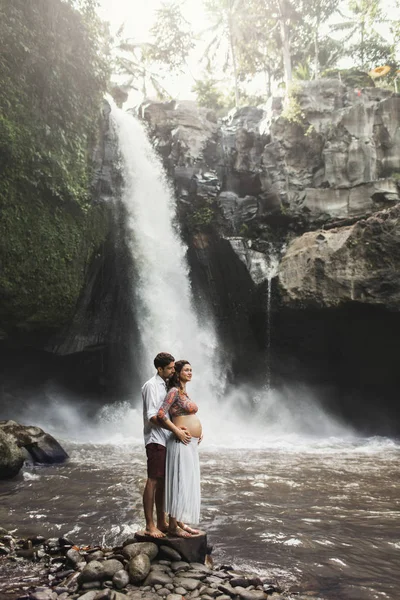 Молода вагітна пара закохана в дивовижний вид Тегенунгана — стокове фото