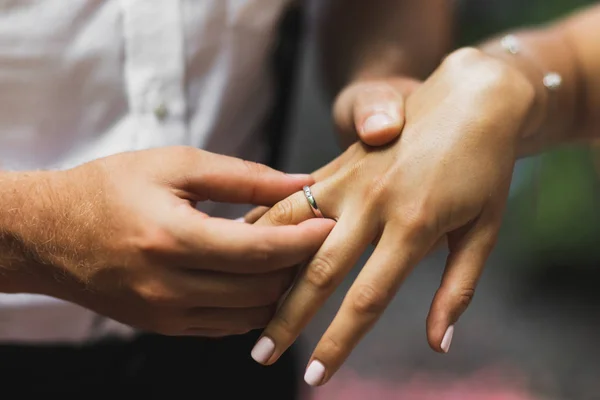 Homem usando anel de casamento na mão da mulher de perto. Símbolo do amor — Fotografia de Stock