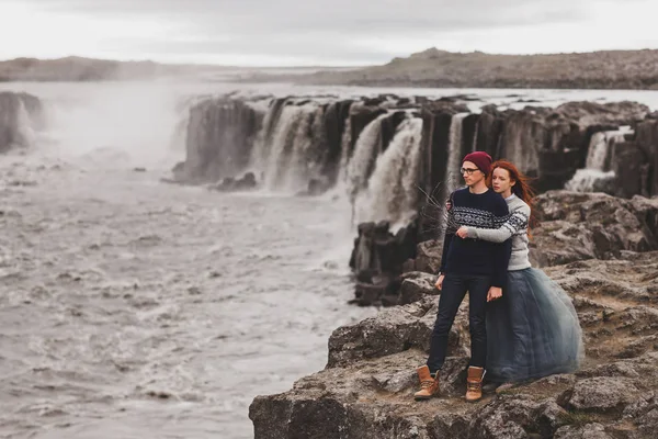 Pasangan hipster yang bahagia jatuh cinta berjalan di dekat air Selfoss yang populer — Stok Foto