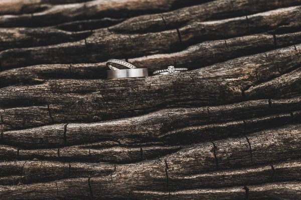 Üç düğün ve teklif yüzükleri. Tahta kahverengi değerli taşlar. 