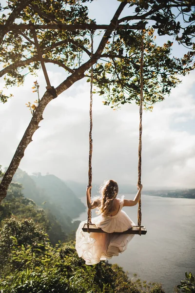 Женщина качается на свежем воздухе над удивительными горами, джунглями и озерами v — стоковое фото