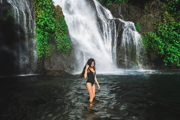 Jeune femme brune mince avec les cheveux bouclés profiter dans la lagune de — Photo