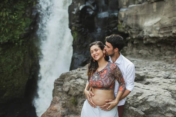 Jovem casal grávida apaixonado com vista incrível de Tegenungan c — Fotografia de Stock