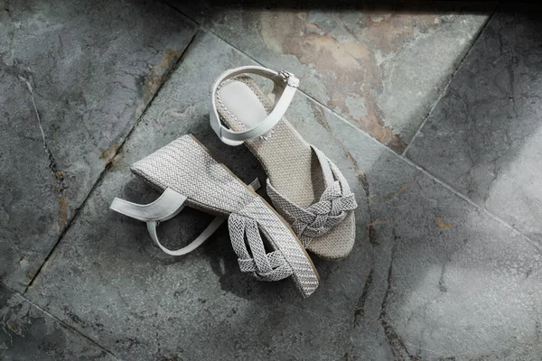Женщина серые плетеные туфли на модном бетонном фоне плитки пола — стоковое фото