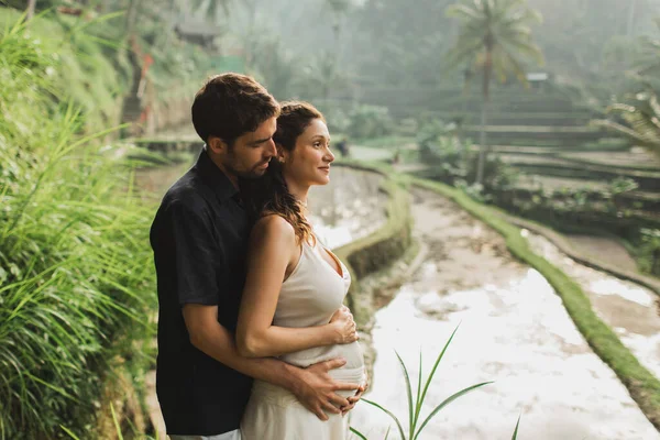 Giovane donna incinta latina con marito con splendida vista di Ubu — Foto Stock