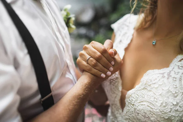 Bruidegom en bruid die elkaars hand vasthouden. Symbool van liefde en communicatie — Stockfoto