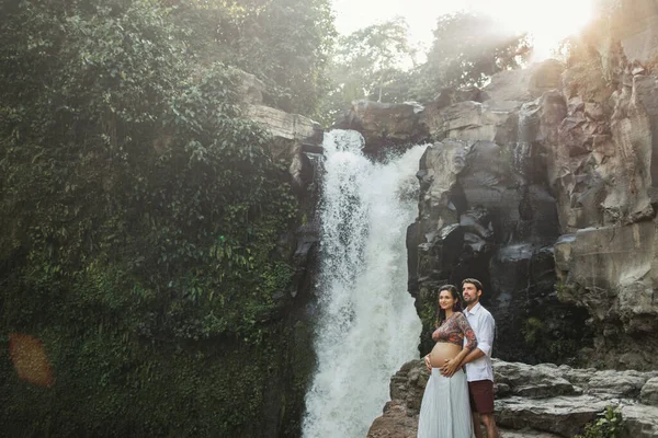 Joven Pareja Embarazada Enamorada Increíble Vista Cascada Tegenungan Luz Del —  Fotos de Stock