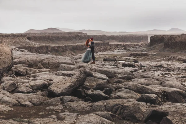 アイスランドで歩くこととキスをすることが大好きですどこの真ん中に石の火山砂漠の周り 劇的な北欧の風景 寒い天候 伝統的なウールのセーター ジーンズ グレーのスカートを身に着けている — ストック写真