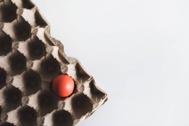 Beyaz arka plandaki kutuda kırmızı boyalı bir Paskalya yumurtası. Üst Manzara. Paschal konsepti.