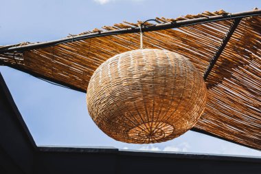 Siyah duvarlı, turuncu renkli el yapımı saman lambası. İç tasarımda çevre ve doğal kavram. Modern kafe çatısı. Çağdaş basit biçim.