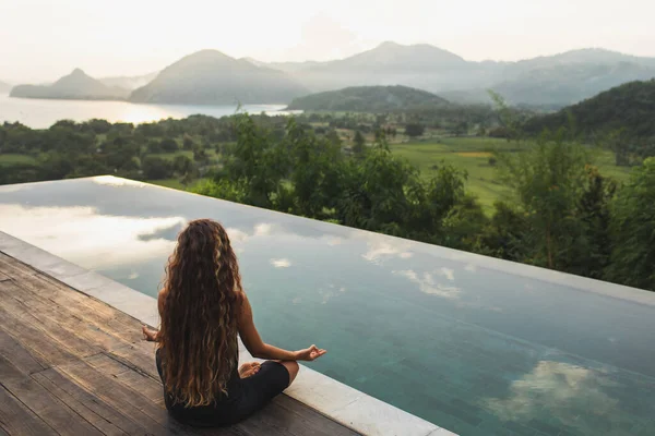 Gün Doğumunda Ufukta Dağlarla Birlikte Sonsuz Havuz Kenarında Meditasyon Yapan — Stok fotoğraf