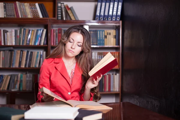 Chica leyendo un libro en la biblioteca — Foto de Stock