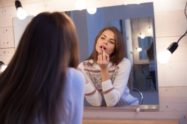 Kız kendini aynanın önünde makyaj makyaj yapar