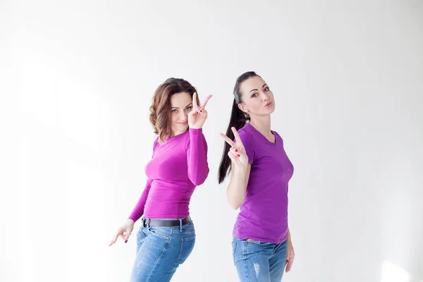 Dvě ženy ve fialové oblečení ukazují prsty — Stock fotografie