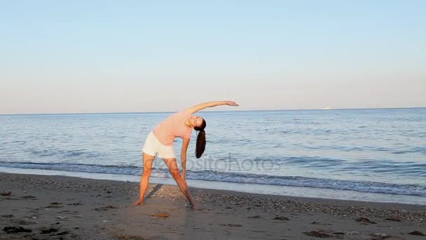 Mädchen treibt Sport am Strand am Meer — Stockvideo