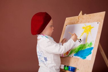 küçük çocuk sanatçı fırça ve boya boya bir resim