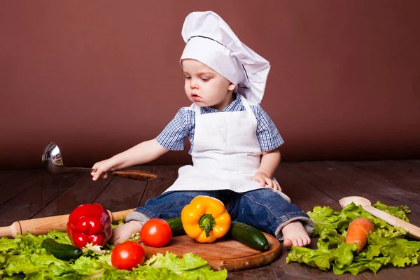 Mały chłopiec Cook marchew, papryka, pomidory, sałata, — Zdjęcie stockowe