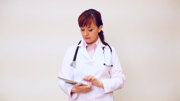 Arzt mit Stethoskop im Krankenhaus beobachtet die Diagnose in der Tablette — Stockvideo