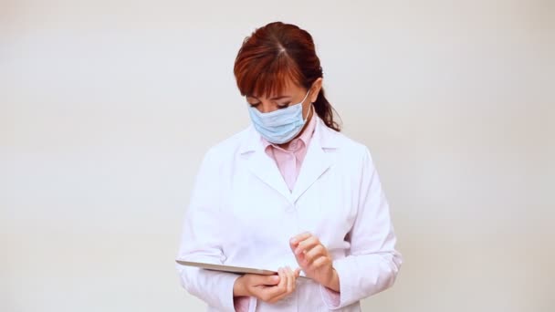 Médecin avec stéthoscope à l'hôpital regardant le diagnostic dans la tablette — Video