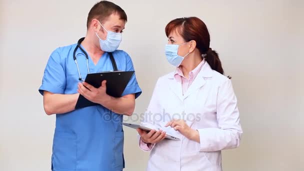 Arzt mit Stethoskop berät Krankenschwester im Krankenhaus mit Tablette — Stockvideo