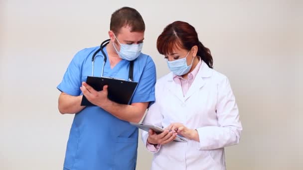 Arzt mit Stethoskop berät Krankenschwester im Krankenhaus mit Tablette — Stockvideo