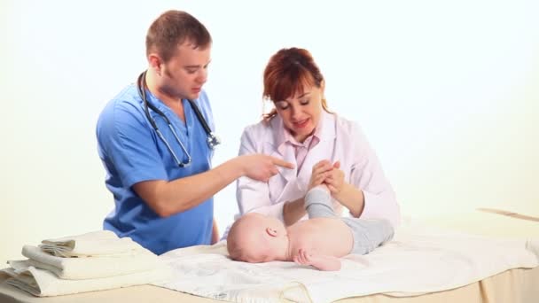 O médico é uma enfermeira como massagear um bebê — Vídeo de Stock