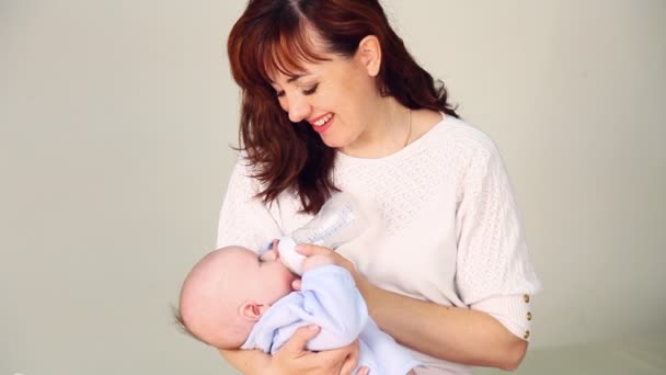 Mamá está alimentando al bebé con leche de un biberón — Vídeos de Stock