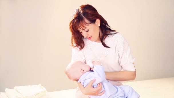 Mamá está alimentando al bebé con leche de un biberón — Vídeo de stock
