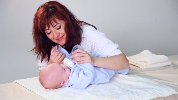 Moeder is het voeden van de baby melk uit een fles — Stockvideo