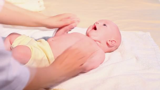 O médico faz massagem mãos pés bebê menino — Vídeo de Stock