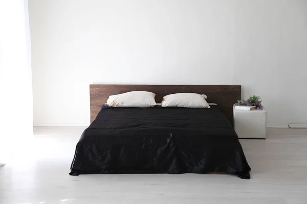 Interior branco quarto e cama com lençóis pretos — Fotografia de Stock