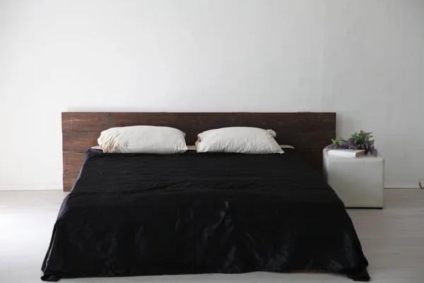 Interior branco quarto e cama com lençóis pretos — Fotografia de Stock