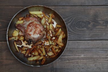 bir tablo üzerinde et ve patates tava ile akşam yemeği kızarmış