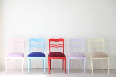 Beyaz Oda renkli sandalyeler mavi sarı kırmızı mavi mor
