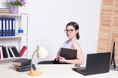 bir bilgisayarda Office kağıt klasörlerde iş kız oturuyor