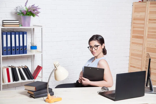 bir bilgisayarda Office kağıt klasörlerde iş kız oturuyor