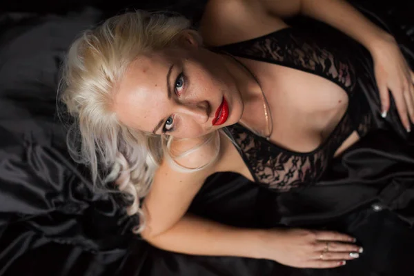 Sexy bionda in nero biancheria intima di seta si trova sul letto — Foto Stock