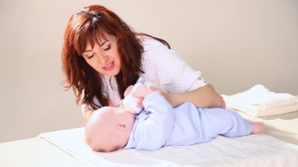 Mamá está alimentando al bebé con leche de un biberón de amor — Vídeos de Stock